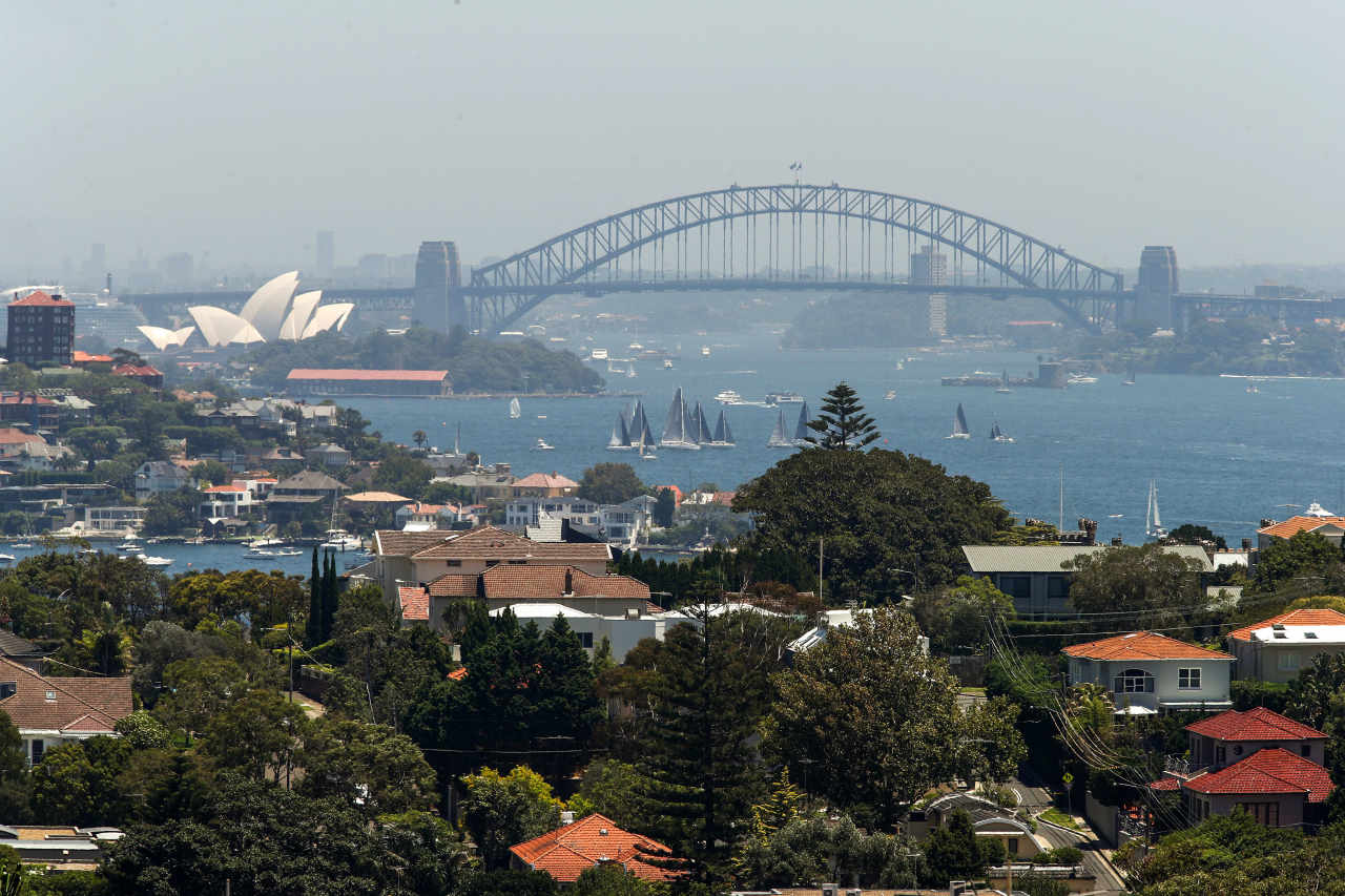 Residential buildings and houses stand as the Sydney Harbour Bridge and Sydney Opera House stand in the background in Sydney, Australia, on Saturday, Jan. 12, 2019.